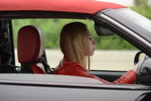 A young woman driving her car in the rain