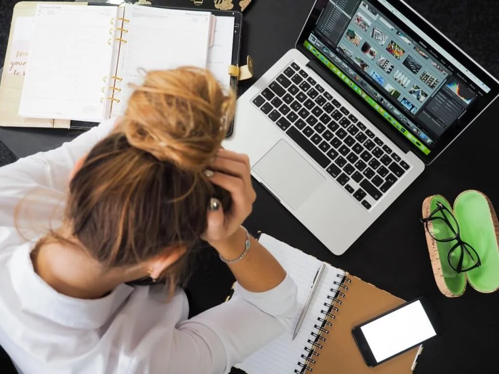 Woman stressed out in front of her laptop due to workplace harassment