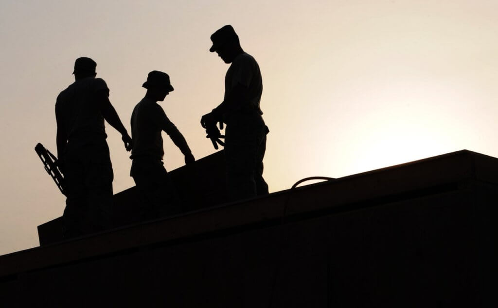 Three men working overtime as the sun comes down