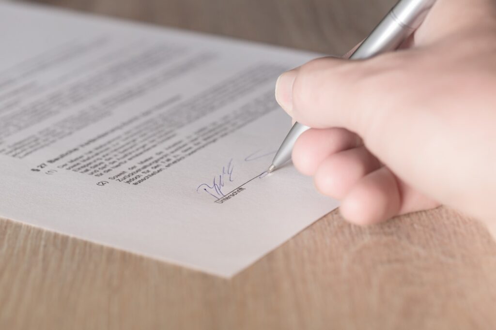 writing signature on white paper with blue ink for severance agreement