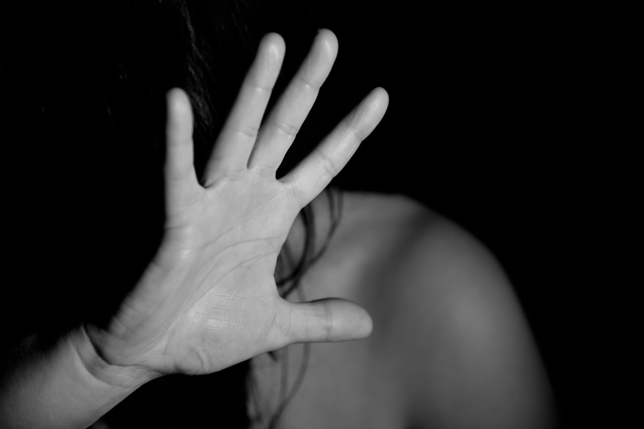 black and white image of woman covering her face due to fear of sexual harassment