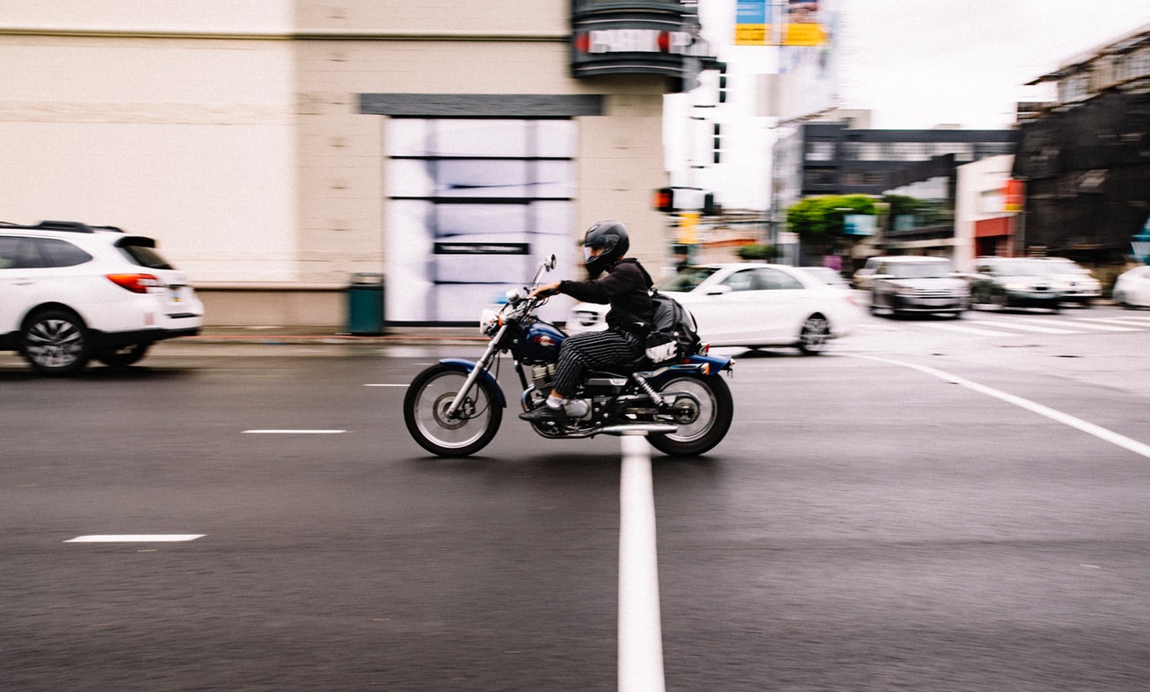man riding a motorcycle fast on the road