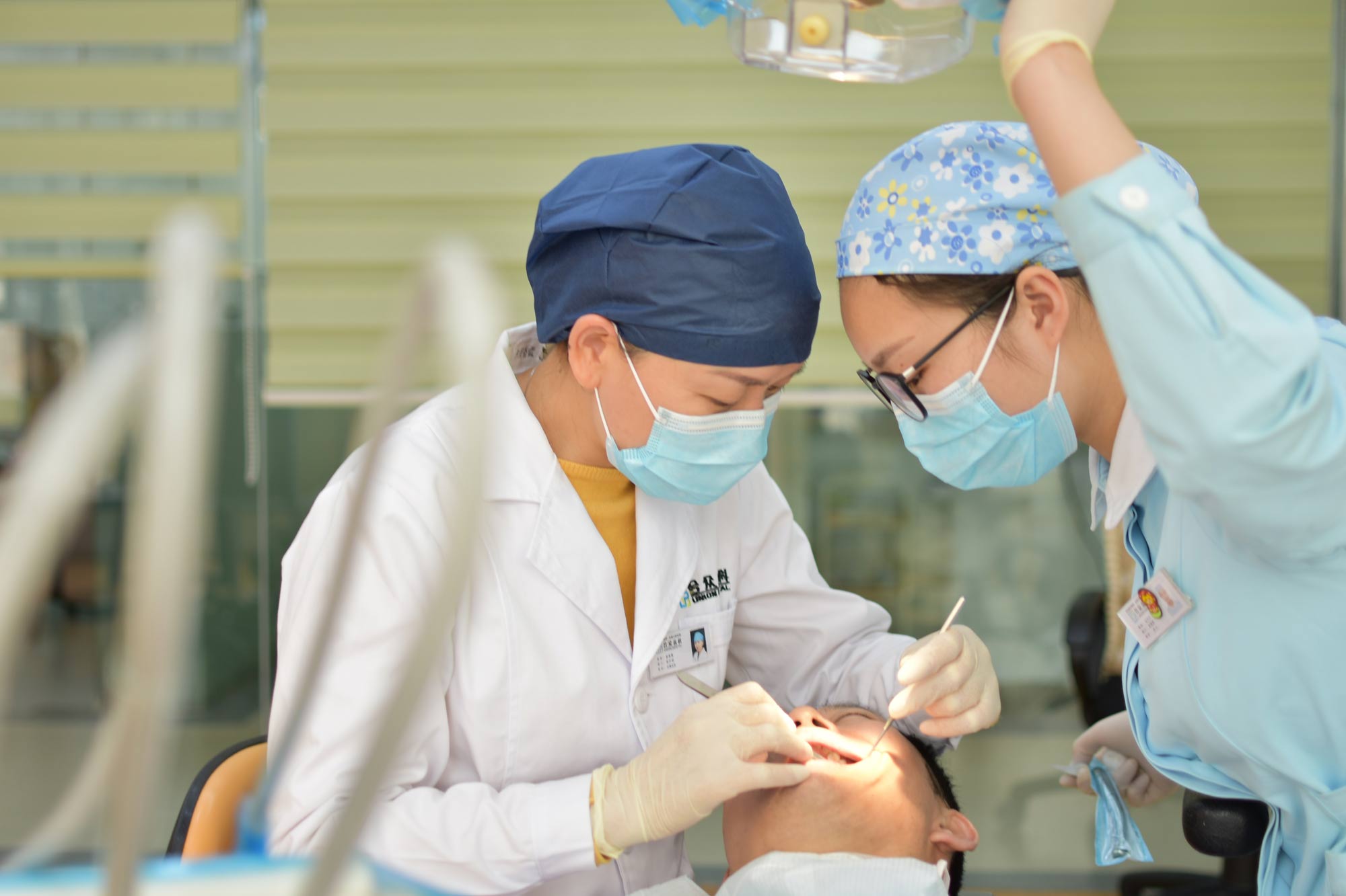 two dentists performing a dental procedure on a patient
